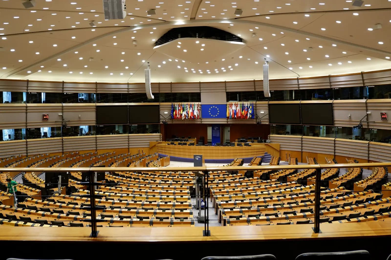 European Parliament chamber with rows of seats and European flags